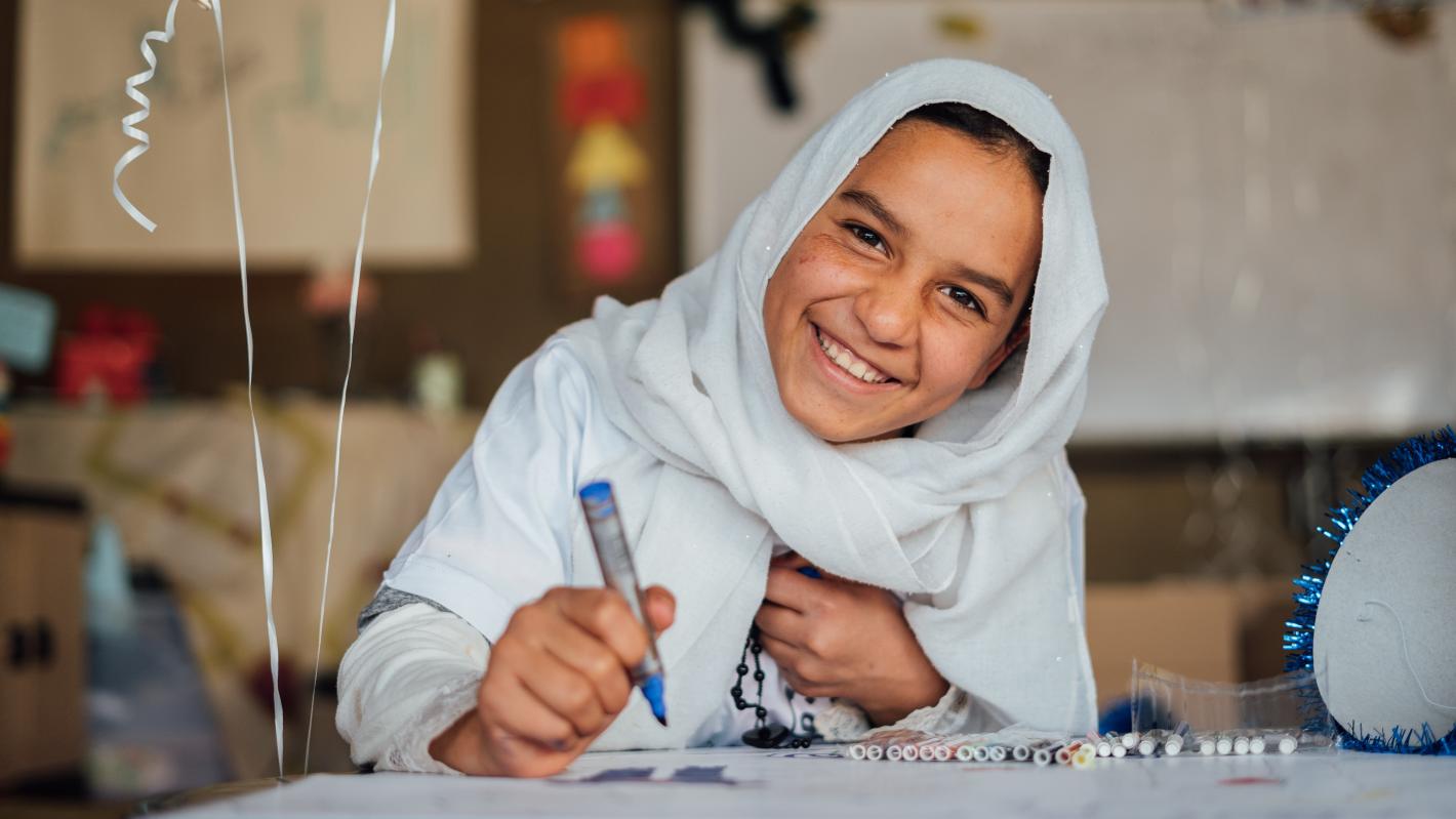 Child laughing and writing something.