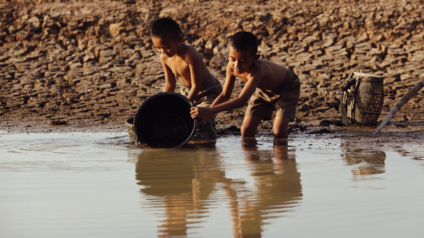 Children trying to collect water in a bucket