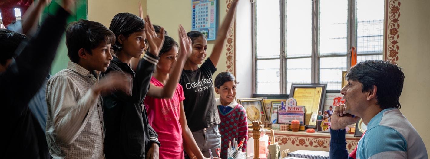 Children raising hands to ask questions.