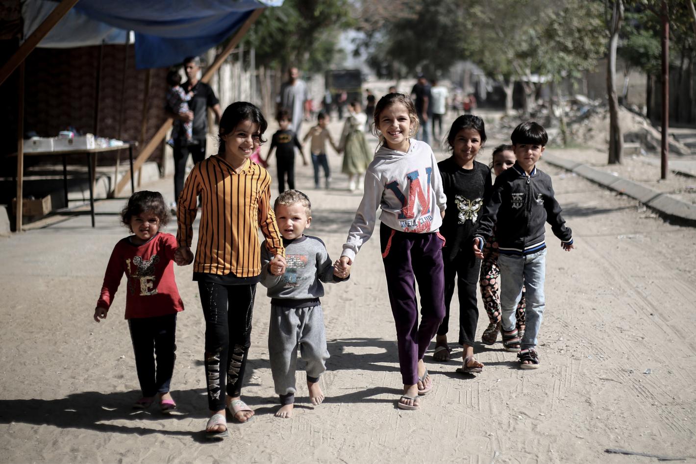 A group of children holding hand in a camp in Gaza.